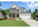 Charming two-story home with a well-manicured lawn, inviting porch swing, and attached two-car garage at 2933 Creek Moss Ave, Wake Forest, NC 27587