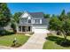 Beautiful two-story home with a manicured lawn, front porch swing, and a spacious driveway leading to a garage at 2933 Creek Moss Ave, Wake Forest, NC 27587
