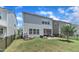 Backyard of the home featuring a stone patio with grill, seating, and a fenced lawn at 2969 Thirlestane Dr, Apex, NC 27502