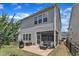 Backyard view showcasing a stone patio, grill, fenced yard, and covered seating area at 2969 Thirlestane Dr, Apex, NC 27502