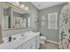 Bright bathroom featuring a large mirror, white vanity, and shower with floral-themed curtain at 2969 Thirlestane Dr, Apex, NC 27502