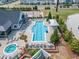 Aerial view of a community pool with lounge chairs, a hot tub, and landscaped areas at 2969 Thirlestane Dr, Apex, NC 27502
