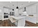 Modern kitchen features white cabinets, stainless steel appliances, a center island with seating, and pendant lights at 2969 Thirlestane Dr, Apex, NC 27502