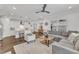 Open-concept living room adjacent to kitchen, featuring a comfortable sectional sofa, accent chair, and hardwood floors at 2969 Thirlestane Dr, Apex, NC 27502