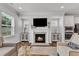Cozy living room with a fireplace, built-in cabinets, a large TV, and lots of natural light at 2969 Thirlestane Dr, Apex, NC 27502