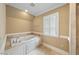 Bathroom with a large soaking tub and tiled surround, as well as a bright window at 305 Lochridge Dr, Roxboro, NC 27573