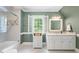 Bathroom with a tiled shower, white vanity and toilet, and shuttered windows at 305 Lochridge Dr, Roxboro, NC 27573