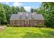 Beautiful brick home featuring dormer windows and manicured landscaping at 305 Lochridge Dr, Roxboro, NC 27573