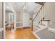 Welcoming foyer with hardwood floors, a staircase, and a decorative light fixture at 305 Lochridge Dr, Roxboro, NC 27573
