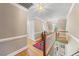Upstairs hallway with wooden floors, natural lighting, and railing overlooking the foyer at 305 Lochridge Dr, Roxboro, NC 27573