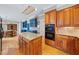 Well-equipped kitchen with wood cabinets, granite countertops, and a view into the dining area at 305 Lochridge Dr, Roxboro, NC 27573