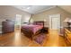 Spacious main bedroom with wooden floors, neutral paint, and a doorway to the ensuite bathroom at 305 Lochridge Dr, Roxboro, NC 27573