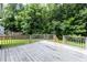 Overlooking a green lawn, this home's back deck has a traditional wood railing at 3110 Trinness Dr, Durham, NC 27707