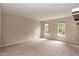 An open bedroom space with plush carpet and two bright, sunny windows at 3110 Trinness Dr, Durham, NC 27707
