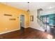 Inviting entryway with hardwood floors, bright yellow accent wall, and staircase leading to the second floor at 3110 Trinness Dr, Durham, NC 27707