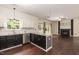 Open kitchen with granite countertops, stainless steel appliances, and view into the living room with a fireplace at 3110 Trinness Dr, Durham, NC 27707