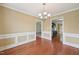 Formal dining room with hardwood floors, wainscoting, neutral paint, and an elegant chandelier, ready for gatherings at 33 Bluestone Dr, Smithfield, NC 27577