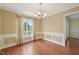 Charming dining room with hardwood floors, wainscoting, soft lighting and window to let natural light in at 33 Bluestone Dr, Smithfield, NC 27577