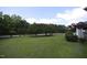 Large grassy backyard featuring mature trees, manicured shrubs, and a white picket fence at 3409 Bennyfield Ct, Fuquay Varina, NC 27526