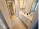 Bathroom featuring double sinks, white cabinetry, and a walk-in closet for storage at 3409 Bennyfield Ct, Fuquay Varina, NC 27526