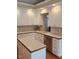Well-lit kitchen with white cabinets, tile countertops, stainless steel dishwasher, and wood floors at 3409 Bennyfield Ct, Fuquay Varina, NC 27526