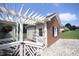 Charming outbuilding boasts brick accents and a white pergola for added curb appeal at 3409 Bennyfield Ct, Fuquay Varina, NC 27526