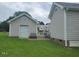 View of detached garage and patio in well-maintained, grassy backyard at 3409 Bennyfield Ct, Fuquay Varina, NC 27526