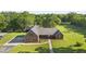 Aerial view of a charming brick home with a large yard, mature trees, and outbuildings on a beautiful property at 3537 Sweetgum Rd, Gibsonville, NC 27249