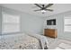 This bedroom features a ceiling fan, TV, wood dresser, wood-look flooring, and two windows at 3537 Sweetgum Rd, Gibsonville, NC 27249