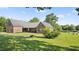 Exterior of a well-maintained brick home with a covered porch, lush greenery, and a serene pond view at 3537 Sweetgum Rd, Gibsonville, NC 27249