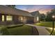 Charming brick home showcasing a covered front porch, lush green lawn, and a welcoming pathway at twilight at 3537 Sweetgum Rd, Gibsonville, NC 27249