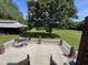 Back patio with outdoor furniture overlooking large, well-manicured lawn and mature trees at 3537 Sweetgum Rd, Gibsonville, NC 27249