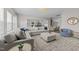 Bright, open-concept living room featuring a large sectional sofa, modern lighting, and seamless flow to the kitchen at 3613 Cross Timber Ln, Raleigh, NC 27603