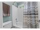Updated bathroom featuring a white tile shower and tub with a striped shower curtain at 3720 Bridgeton Park Dr, Raleigh, NC 27612