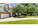 View of the home's garage and extended driveway surrounded by lush landscaping at 3720 Bridgeton Park Dr, Raleigh, NC 27612