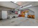 Large two car garage featuring built in cabinets, refrigerator, workbench and overhead storage at 3720 Bridgeton Park Dr, Raleigh, NC 27612