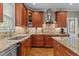 A kitchen is shown with granite countertops, stainless steel appliances and wooden cabinets at 3720 Bridgeton Park Dr, Raleigh, NC 27612