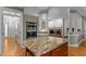 A kitchen is shown with a granite island and built-in ovens, leading to the living room with fireplace at 3720 Bridgeton Park Dr, Raleigh, NC 27612