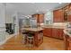 A kitchen is shown with an island and two stools with stainless steel appliances and wooden cabinets at 3720 Bridgeton Park Dr, Raleigh, NC 27612