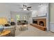 A living room is shown with a brick fireplace, sofas and two windows with a ceiling fan at 3720 Bridgeton Park Dr, Raleigh, NC 27612
