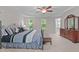 Comfortable main bedroom featuring a tray ceiling, ceiling fan, dresser and natural light from windows at 3720 Bridgeton Park Dr, Raleigh, NC 27612