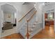 Staircase with carpeted steps, wood handrail, and views into the living room and kitchen at 3720 Bridgeton Park Dr, Raleigh, NC 27612