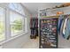 Organized walk-in closet with shelves and rods, and a secure gun safe beside a sunlit window at 3720 Bridgeton Park Dr, Raleigh, NC 27612