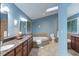 This primary bathroom has dual sinks, a tub, a toilet, and natural light at 3833 Hidden Branches Dr, Raleigh, NC 27613