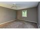 Neutral-toned bedroom with a ceiling fan, window views, and a calming ambiance at 3833 Hidden Branches Dr, Raleigh, NC 27613