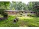 Home exterior with wooden deck, surrounded by lush trees, offering a blend of comfort and nature at 3833 Hidden Branches Dr, Raleigh, NC 27613