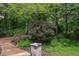 Beautifully landscaped yard with mature trees and stone accents enhances the property's curb appeal at 3833 Hidden Branches Dr, Raleigh, NC 27613
