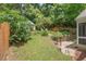 Landscaped backyard with mature trees, terraced landscaping, and privacy fence at 414 W Markham Ave, Durham, NC 27701