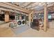 Unfinished basement features exposed ductwork, washer and dryer, and storage at 414 W Markham Ave, Durham, NC 27701