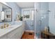 Charming bathroom featuring blue tile, glass shower, marble countertops and gold hardware at 414 W Markham Ave, Durham, NC 27701